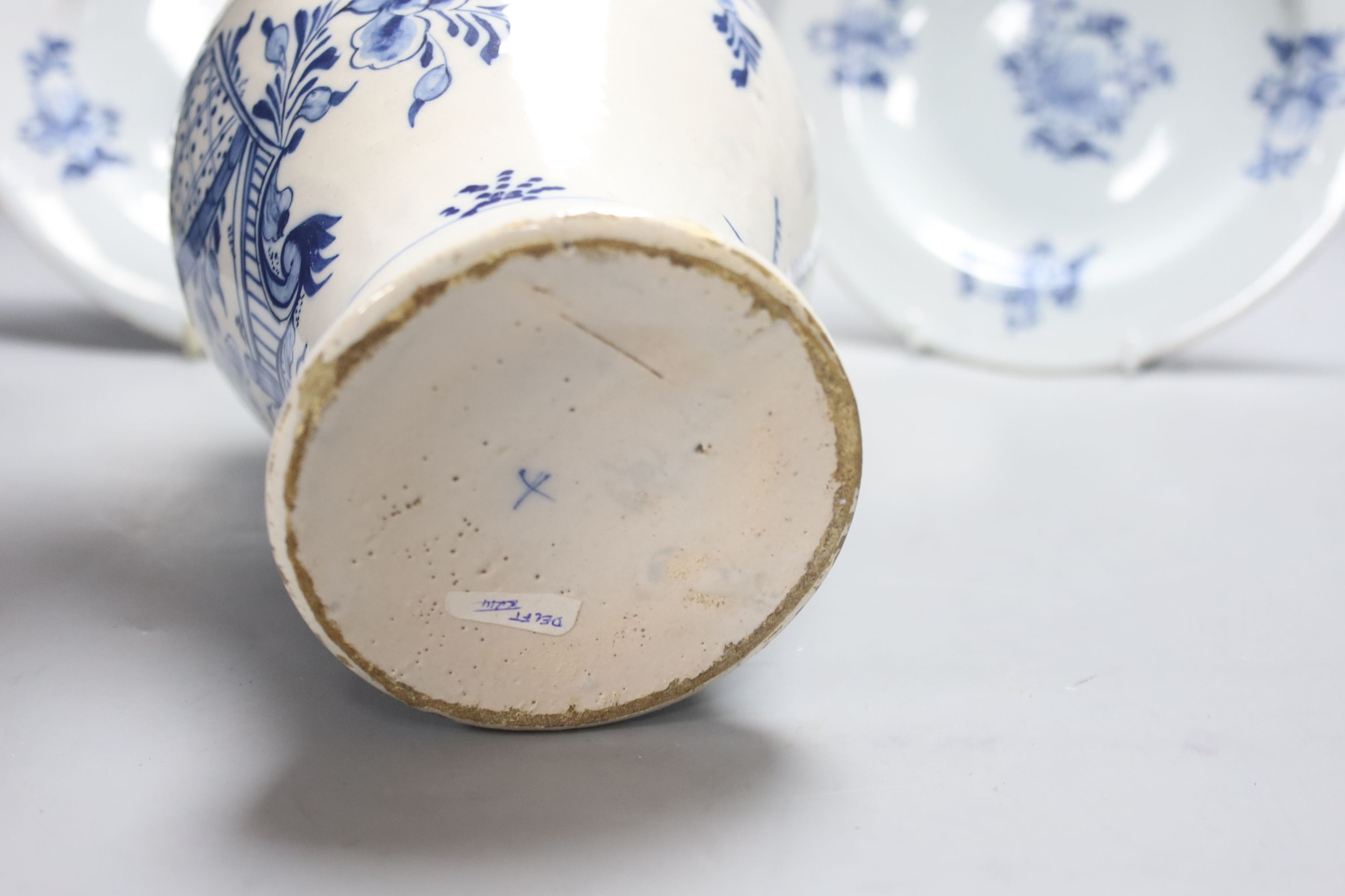 A mid-18th century Dutch Delft flower and fence-decorated blue and white baluster vase, a similar plate and a pair of English delft plates, H 20cm (vase)